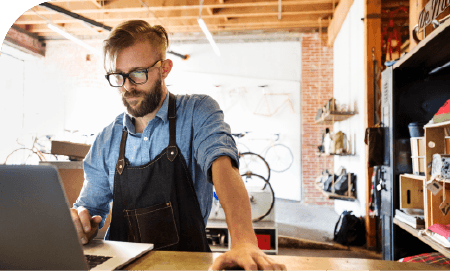 un artisan derrière son laptop dans son atelier de réparation de vélo