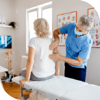 femme de dos chez l'ostéopathe lui pratiquant des soins sur son dos