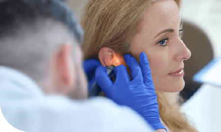 une femme se faisant contrôler son oreille