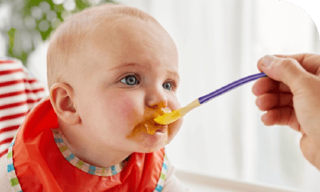 Un bébé en train de manger à cuillère