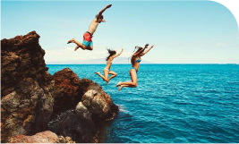 3 jeunes heureux en maillot de bain qui sautent dans la mer 