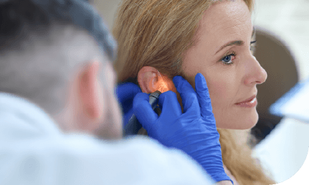 une femme se faisant contrôler son oreille