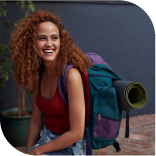 Une jeune femme souriante avec un sac à dos de voyage