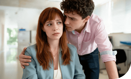 un jeune homme murmurant quelque chose à l'oreille d'une jeune fille la mettant mal à l'aise