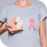 zoom sur un t-shirt gris d'une femme tenant un donut sur son sein droit et avec un ruban rose sur le sein gauche