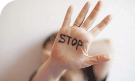 Une femme avec la main ouverte sur laquelle il est écrit stop
