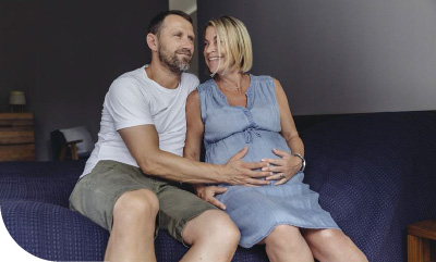 un homme touchant le ventre de sa femme enceinte