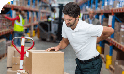 Manutentionnaire avec un transpalette sur son lieu de travail se tenant le dos de douleur