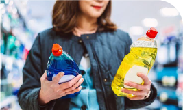 Une femme regarde des bouteilles de produit vaisselle