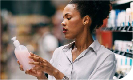 Femme regardant l'étiquette d'une bouteille de savon