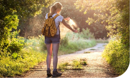 une femme sur un sentier se tapant le bras pour chasser un moustique