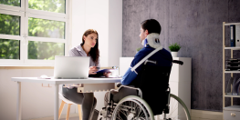 deux personnes qui discutent dont une en fauteuil roulant