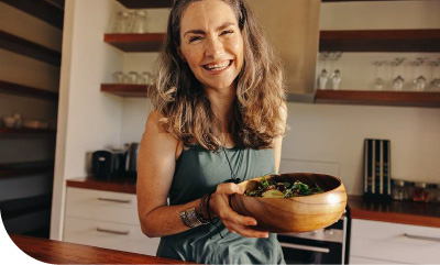 femme souriante avec un plat en bois