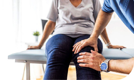 un médecin manipulant le genou d'une femme