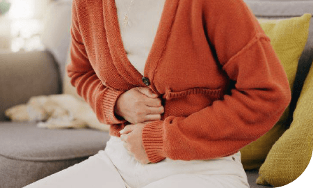 vue serrée d'une personne souffrant de douleurs abdominales les mains sur le ventre