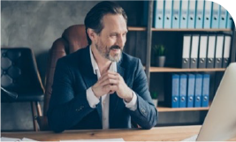 Un homme en costume derrière son bureau