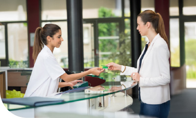 femme tendant sa carte vitale à une pharmacienne