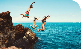 3 jeunes heureux en maillot de bain qui sautent dans la mer 