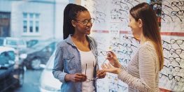 deux femmes chez un opticien l'une d'elle essyant des lunettes