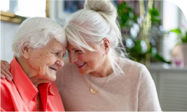 2 femmes seniors souriantes qui font un calin front contre front