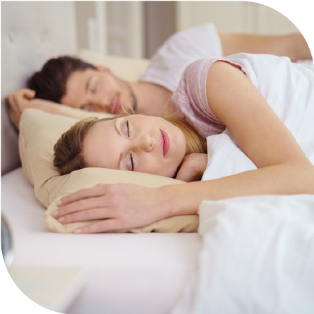 une femme et un homme dorment paisiblement dans un lit