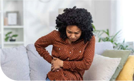 Une femme se tient le côté de la hanche et semble avoir mal