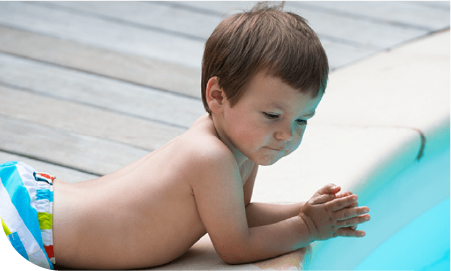 Un bébé allongé au sol et qui regarde la pisicne